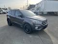 A 2019 Ford Escape in gray with black wheels parked at an angle showcasing its front and side profile