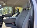 Interior view of a 2017 Ford F-350 SD showing the driver's seat and center console with fabric upholstery and cup holders