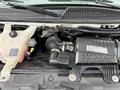 The engine compartment of a 2020 Chevrolet Express showing the Vortec engine with visible components like the air intake and fluid reservoirs