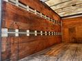 2007 GMC W3500 truck with a wooden interior and metal wall strips designed for cargo transport