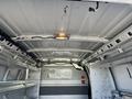 Interior view of a 2014 Chevrolet Express cargo van showing metal shelves and a ceiling light