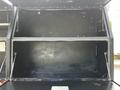 Interior view of a 2016 Ford F-550 truck bed with a black finish featuring two storage compartments without any items inside