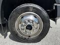 Close-up of a chrome wheel and tire on a 2009 Ford F-550 featuring a shiny hubcap and textured rubber tread