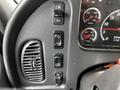 Close-up of the dashboard controls in a 2012 Freightliner M2 106 featuring several buttons gauges and an air vent