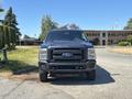 A 2014 Ford F-250 Super Duty truck with a black exterior is parked, facing forward with a bold front grille and a rugged stance
