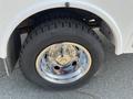 Close-up of a wheel on a 2015 Ford F-450 SD featuring a shiny chrome rim and a rugged tire with deep tread patterns