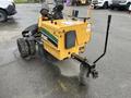 A yellow 2014 Vermeer Corporation Sweep Stump Cutter with large rear wheels and a cutting head at the front is positioned on a paved surface