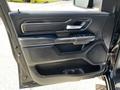 Interior door panel of a 2019 RAM 1500 featuring a handle control panel and speaker grill with a black plastic and leather finish