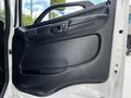 Close-up of the driver's side door panel of a 2020 Hino 338 featuring a black plastic armrest and door handle with a textured finish