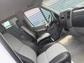 Interiors of a 2009 Dodge Sprinter Van showcasing two front seats with black and grey upholstery and a dashboard with controls and vents visible