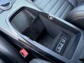 A black and silver center console of a 2020 Alfa Romeo Stelvio featuring a storage compartment and USB ports