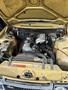 A 1978 Volvo 244 with its hood raised displaying a yellow engine compartment featuring various mechanical components and a visibly aged engine.