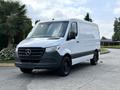 A 2021 Mercedes-Benz Sprinter van with a white exterior and black front grille parked on a driveway