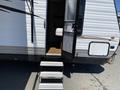 A 2016 Jayco 265RLSW travel trailer with a sliding door and steps leading up to the entrance