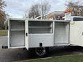 A 2013 RAM 3500 service truck with an open utility body featuring various compartments and shelving inside