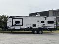 A 2021 Jayco Jay Flight travel trailer with a sleek exterior featuring a black and white design and double axles