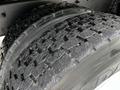 Close-up of a tire from a 2011 International 4400 showing a detailed tread pattern with some dirt and small debris embedded in the grooves