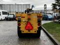 A yellow 2015 International 3000 MT6 vehicle viewed from the rear with a red triangular warning sign and various lights on the back