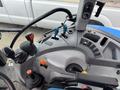 Interior controls of a 2016 New Holland T475 tractor featuring various joysticks levers and knobs for operation