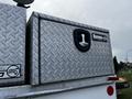 A silver diamond plate tool chest with a black handle labeled Buyers mounted on the back of a vehicle