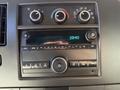 Dashboard control panel of a 2021 Chevrolet Express featuring climate controls and a digital display with time and audio settings