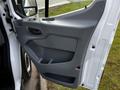 The image shows the interior driver's side door of a 2017 Ford Transit featuring a gray door panel with a handle and a storage compartment