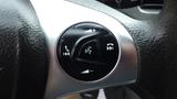 A close-up of a steering wheel control panel featuring buttons for volume adjustment and phone connectivity in a 2018 Ford Transit