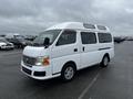 A white 2002 Nissan Van with a distinctive high roof and large windows parked on a paved surface