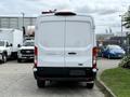 A white 2022 Ford Transit van viewed from the rear with a simple design and no visible markings or logos on the back panel