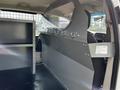 A 2011 Dodge Grand Caravan interior featuring a metal partition with hooks and a storage area on one side