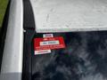 A 2011 Dodge Grand Caravan displaying a red approval sticker in the upper corner of the windshield