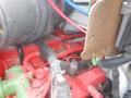 Close-up view of the engine compartment of a 2011 Ford F-750 showing various red and black wires along with metal and rubber components