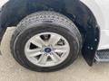 A close-up view of a silver wheel with a chrome five-spoke design mounted on a rugged tire marked Wrangler from Goodyear on a 2019 Ford F-150