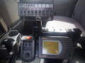 Dashboard controls of a 2016 International WorkStar 7500 featuring various switches a monitor and cup holders