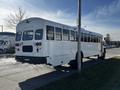 A 2022 Blue Bird Vision school bus parked on a road with visible rear and side features including windows and lights