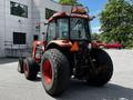 A red 2011 Kubota M8540D tractor with large rear tires and a front loader attachment parked on a paved surface