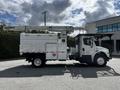 A 2012 Freightliner M2 106 bucket truck with a white body and a raised hydraulic boom for overhead work