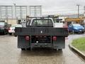 A 2008 Ford F-350 with a flatbed and a rear-mounted hitch is parked facing the camera showcasing its tailgate and back lights