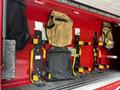 A 1991 Sutphen Deluge fire truck with storage compartments holding firefighting gear and equipment including harnesses and bags