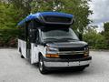 A 2019 Chevrolet Express van with a black and white body and a blue roof, featuring large windows and a spacious front area designed for passenger transport