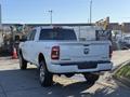 2023 RAM 3500 pickup truck in white with a crew cab and chrome wheels displayed from the rear angle