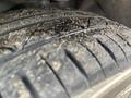 Close-up of a tire from a 2005 Chrysler PT Cruiser showing a worn tread pattern with dirt and debris embedded in the grooves