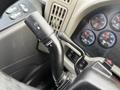A close-up of the wiper control lever on a 2016 International 7400 truck featuring various buttons and gauges in the background