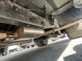 A 1962 Ford F-100 partially visible from below showcasing its exhaust system and undercarriage details