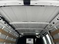 Interior view of a 2023 GMC Savana cargo van showing a white ceiling with metal framing and wooden supports along the sides