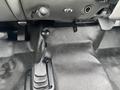 The image shows the gear shift and floor area of a 2005 Ford F-350 SD featuring a manual gear lever and black textured flooring