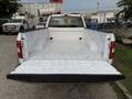 A 2018 Ford F-150 with an empty white truck bed viewed from the rear