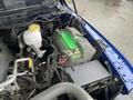 A green battery connected to various cables and components in the engine compartment of a 2019 RAM 1500 Classic