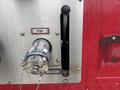A silver intake valve with a handle on a metallic panel labeled "INTAKE" and "CLOSED" attached to a red surface