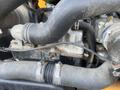 Close-up of the engine components of a 2013 JCB 510-56 Loadall featuring hoses and metal parts interconnected for fuel and air intake